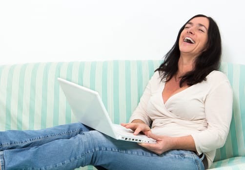 Happy Black haired woman using a laptop