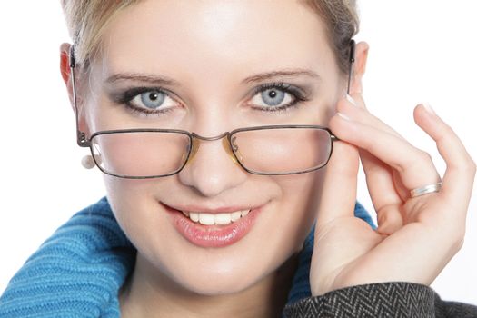 Closeup of beautiful young blonde woman touching her glasses and smiling