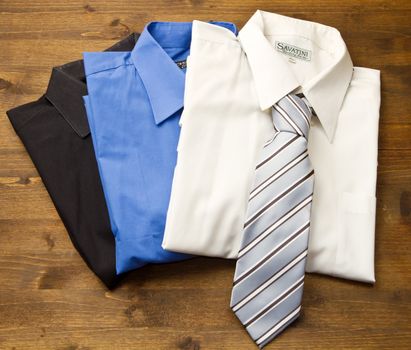 Close up of stacked shirts with tie on wood