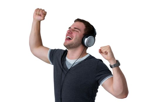 Young Man Listening to music and dancing with arms in air