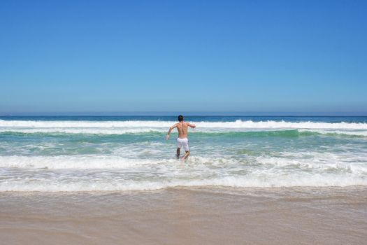 Man running in to indian ocean in south africa