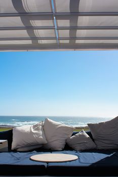 Beach club couch with ocean in the background