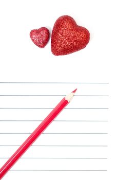 Red pencil and two hearts on a blank love letter