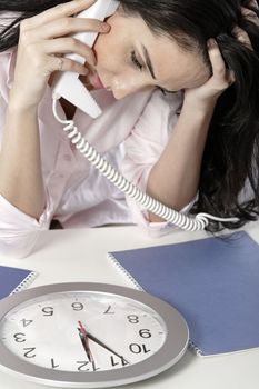 Woman on the phone watching a clock with a deadline approaching