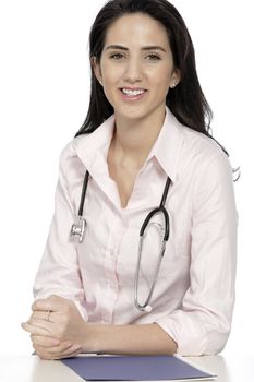 Beautiful young doctor sat smiling at her work desk