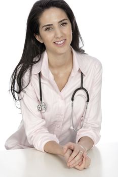 Beautiful young doctor sat smiling at her work desk