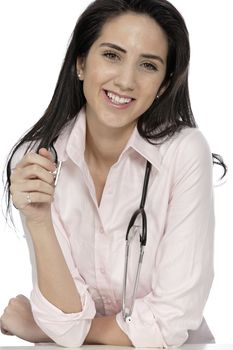 Beautiful young doctor sat smiling at her work desk