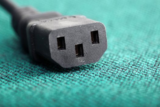 Macro photo of the black power connector on the green background