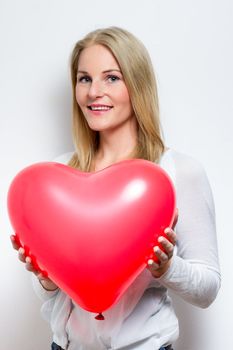 Blond ^Smiling Woman Holding a Heart Balloon