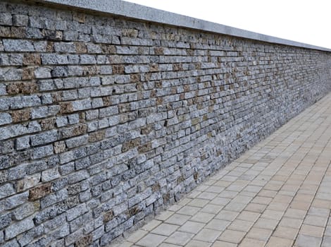 Isolated wall of bricks with granite paving tiles in perspective