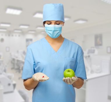 Doctor with pill and apple at lab