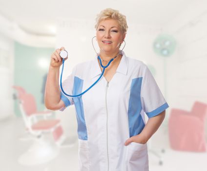 Mature doctor with stethoscope at medical office