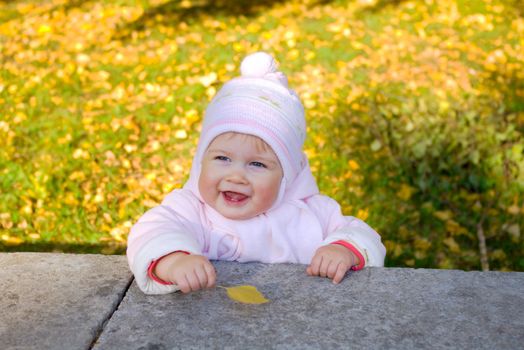 Small smiling baby with yellow leaf