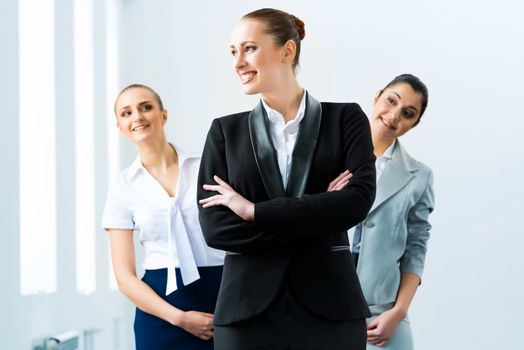 successful business woman in the office, colleagues stare over his shoulder