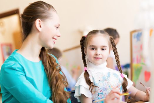 teacher talks to a schoolgirl, working at an art school