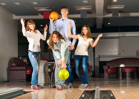 Group of young friends playing bowling, spending time with friends