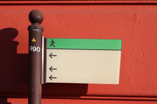 Signpost in front of a red wall