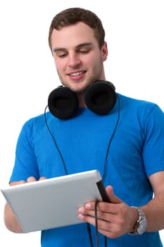 Young man with headphones and blue t-shirt working on a tablet pc