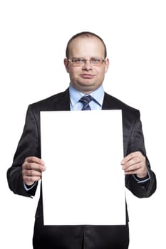 Young man in a black suit holding a blank sheet of paper vertical isolated