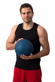 Attractive brunette man in a black tank top and red pants working out with a medicine ball