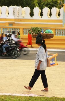 Cambodian woman carrying basket on her head, Phnom Penh, Cambodia