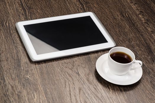 tablet and cup of coffee are on the table, still life