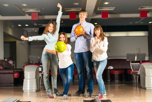 Group of young friends playing bowling, spending time with friends