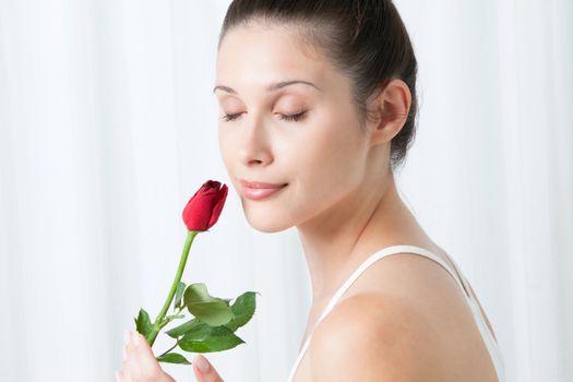 Young woman with a rose, indoors .