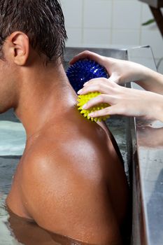 Man receiving a massage in pool.