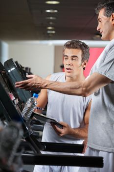 Man asking instructor about machines at health club