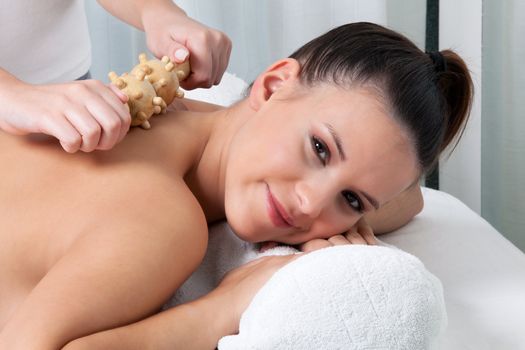 Woman receiving a back massage in spa.