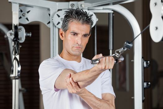 Mature man working out in fitness center