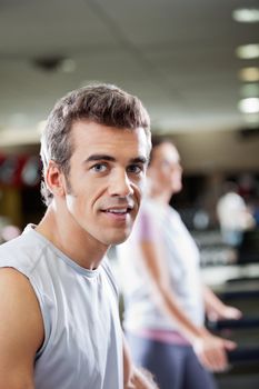 Portrait of young man on treadmill in health club