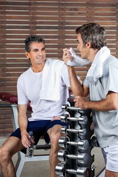 Happy men looking at each other after work out in health club