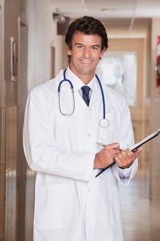 Male Doctor standing with folder at hospital.