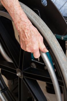 Close-up of hand on the wheel of a wheelchair
