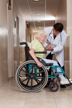 Doctor with patient on wheel chair at hospital.