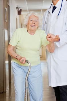 Young doctor assisting a senior woman to walk