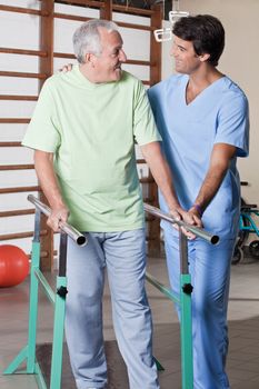 Senior man having ambulatory therapy with his therapist.