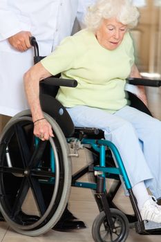 Doctor assisting senior patient sitting in a wheel chair