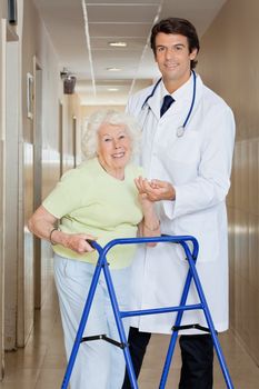 Young happy doctor helping a senior woman with her walker