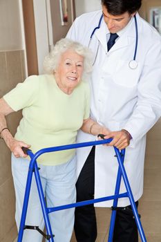 Portrait of a senior woman using walker standing by young doctor