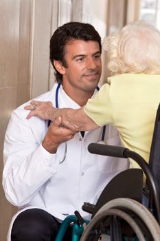 Doctor with patient on wheel chair at hospital.