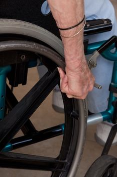 Close-up of Elderly Woman's Hands on wheelchair.