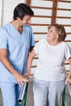 Mature man having ambulatory therapy with his therapist.