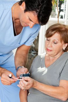 Male nurse measuring glucose level blood test using glucometer and sample strip