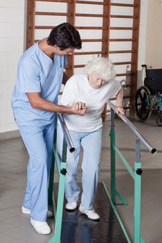 A doctor assisting a senior citizen .