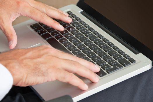 Close-up of hands typing on laptop keyboard
