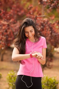 Sport woman checking heart rate in pink watch