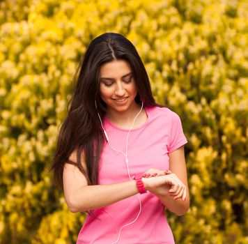 Sport woman checking heart rate in pink watch